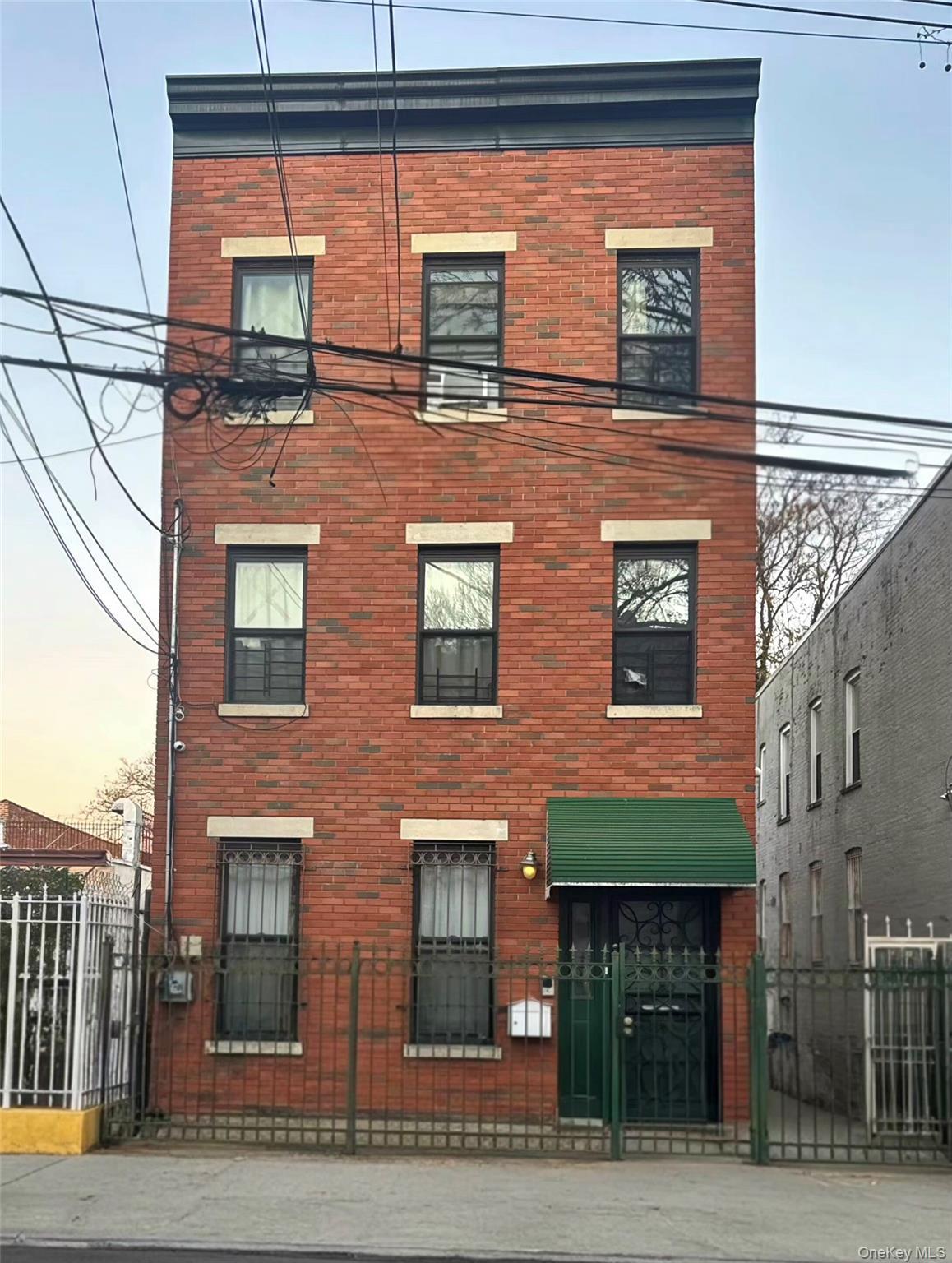View of front facade featuring brick siding and a fenced front yard