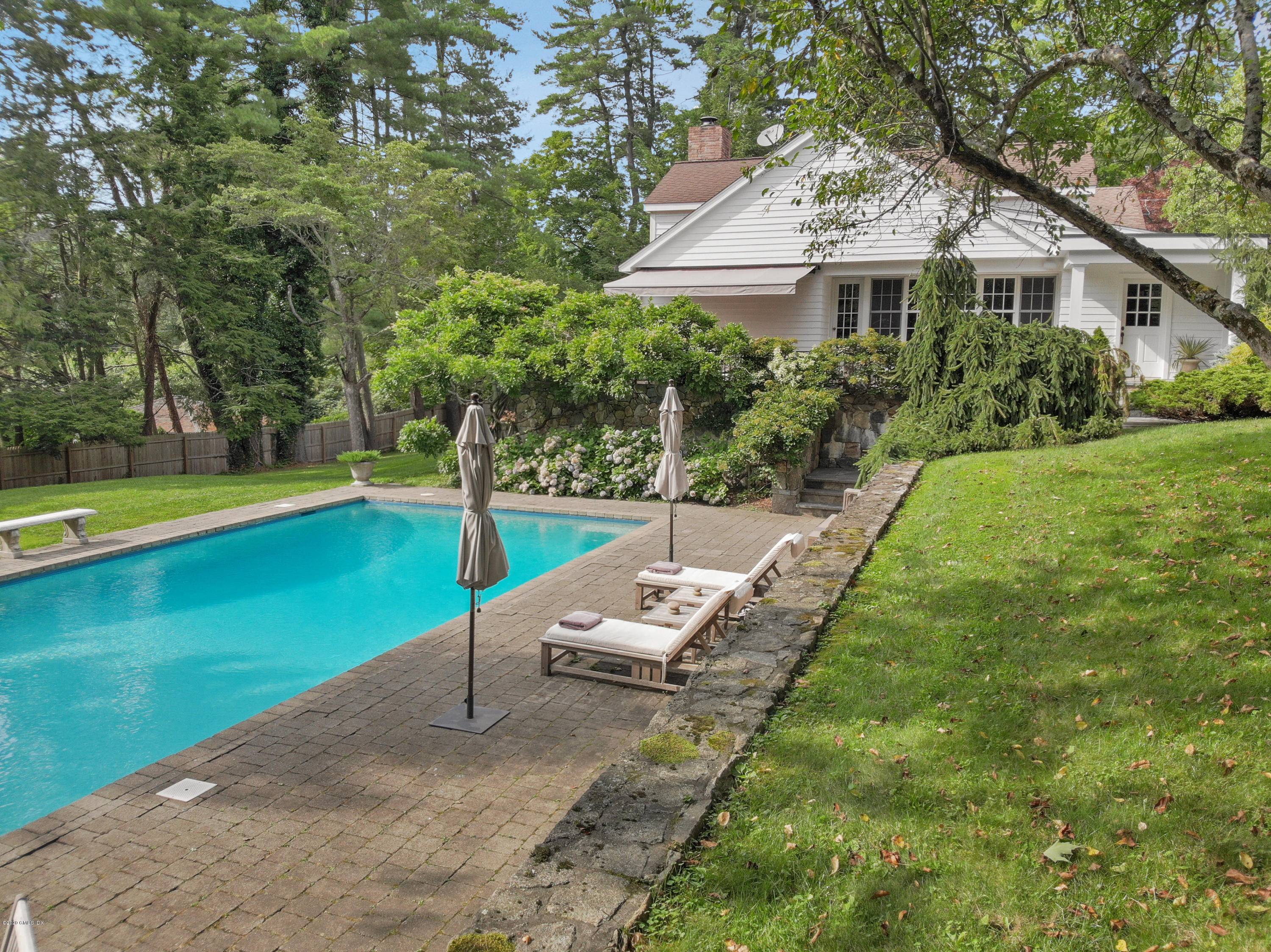 Stone walls abound this elegant country home set off Stanwich Road, and walking distance to Greenwich Country Day School.