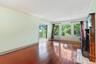 Unfurnished living room featuring ornamental molding, wood finished floors, and a baseboard radiator