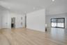 Spacious and open living area filled with natural sunlight from oversized windows, designed for both everyday comfort and entertaining.