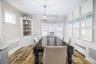 Dining space featuring wood-finish flooring, a built-in corner hutch and a bay window.