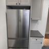 Detailed view of stainless steel refrigerator and wood finished floors