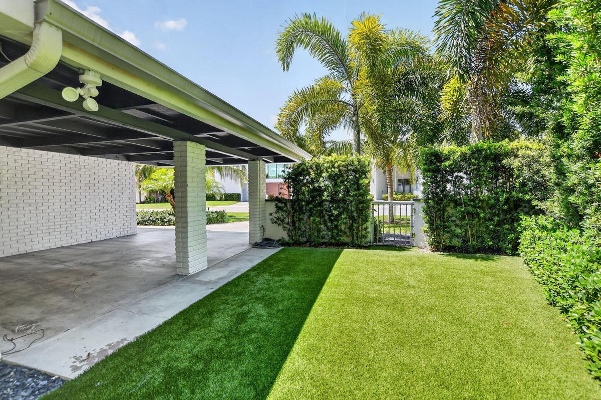 This is the West side elevation of the Carport, the yard is partially fenced in . The side and rear yards have recently installed artificial turf, no