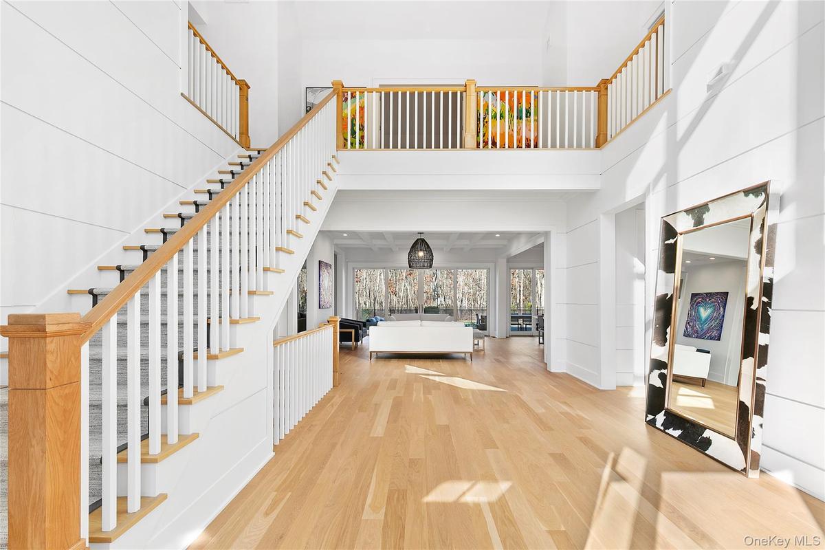 Entryway with wood finished floors, a towering ceiling, and stairs
