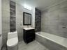 Bathroom featuring vanity, tile walls, and tiled shower / bath