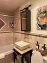 Bathroom featuring toilet, vanity, tile walls, and tiled shower / bath combo