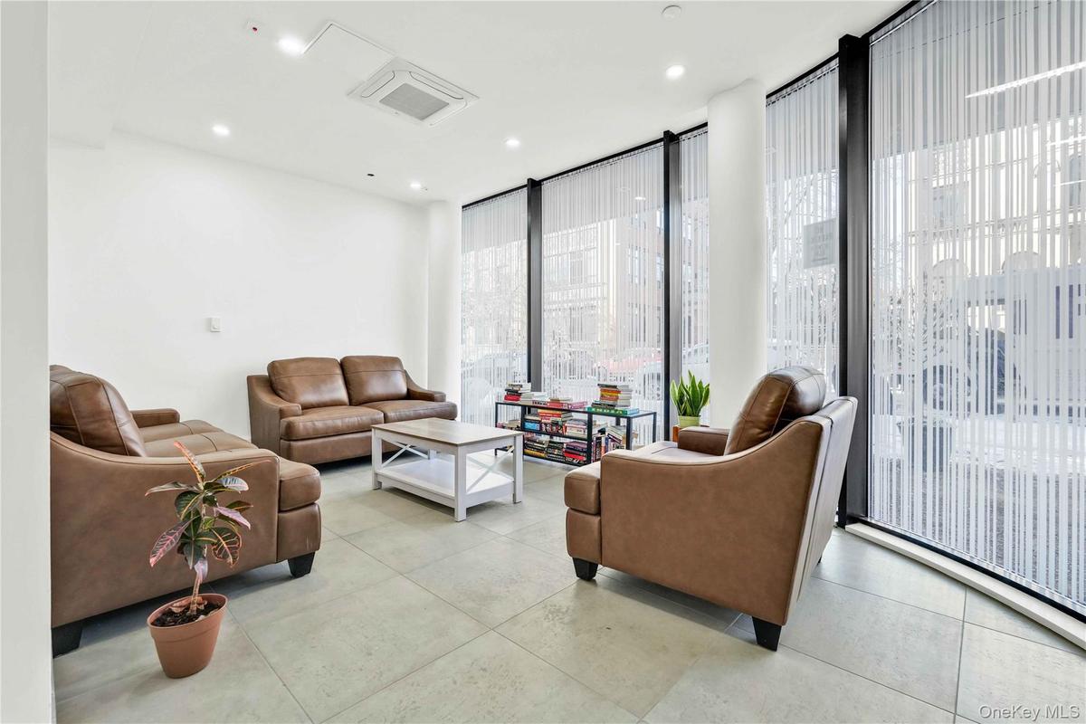 Living room featuring expansive windows, cooling unit, recessed lighting, and light tile patterned floors
