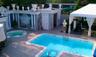 Community pool featuring a community hot tub, a gazebo, a wooden deck, and a patio