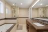 Dual vanity with individual sinks, integrated countertop, and wall-mounted faucets