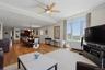 Open-concept living area with abundant natural light, crown molding, and wood-finish flooring