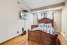 Bedroom with lofted ceiling, a baseboard radiator, light wood-style flooring, and recessed lighting
