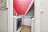 Laundry area with wood tiled floors, wallpapered walls, wainscoting, and washer and clothes dryer