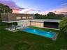 Pool at dusk with a lawn, an outdoor hangout area, an outdoor pool, and a patio area