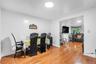 Dining area featuring wood-finish flooring, white walls, and an open entryway to an additional living space