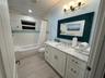 Refreshing and inviting bathroom. Window that allows a gentle breeze. The crisp white tiles and sleek fixtures create a clean and classic aesthetic. A