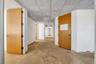 Corridor featuring a drop ceiling and concrete flooring