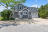 View of front of home featuring gravel driveway, roof with shingles, entry steps, and a garage