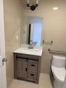 Half bathroom featuring tile walls, vanity, and light tile patterned floors