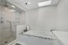 Primary En Suite Walk in Shower with ceiling mounted rain shower head, built in steam unit and whirlpool soaking tub