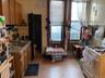Kitchen with brown cabinets, white range with gas cooktop, and freestanding refrigerator