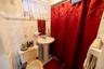 Bathroom with tile walls and a shower with shower curtain