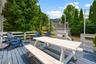 Spacious outdoor deck featuring painted wood flooring and white railings.