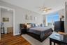 Bedroom 2 with expansive windows illuminate the room, complemented by a ceiling fan with integrated lighting