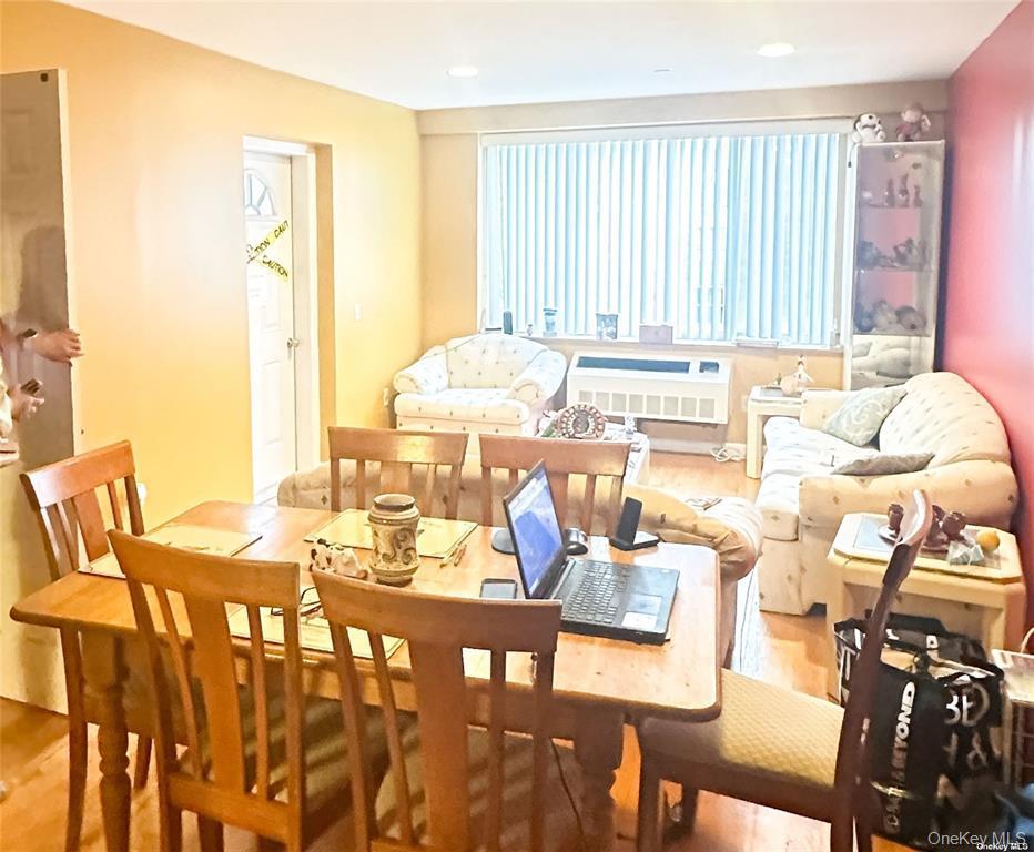 Dining room with radiator, wood finished floors, and recessed lighting