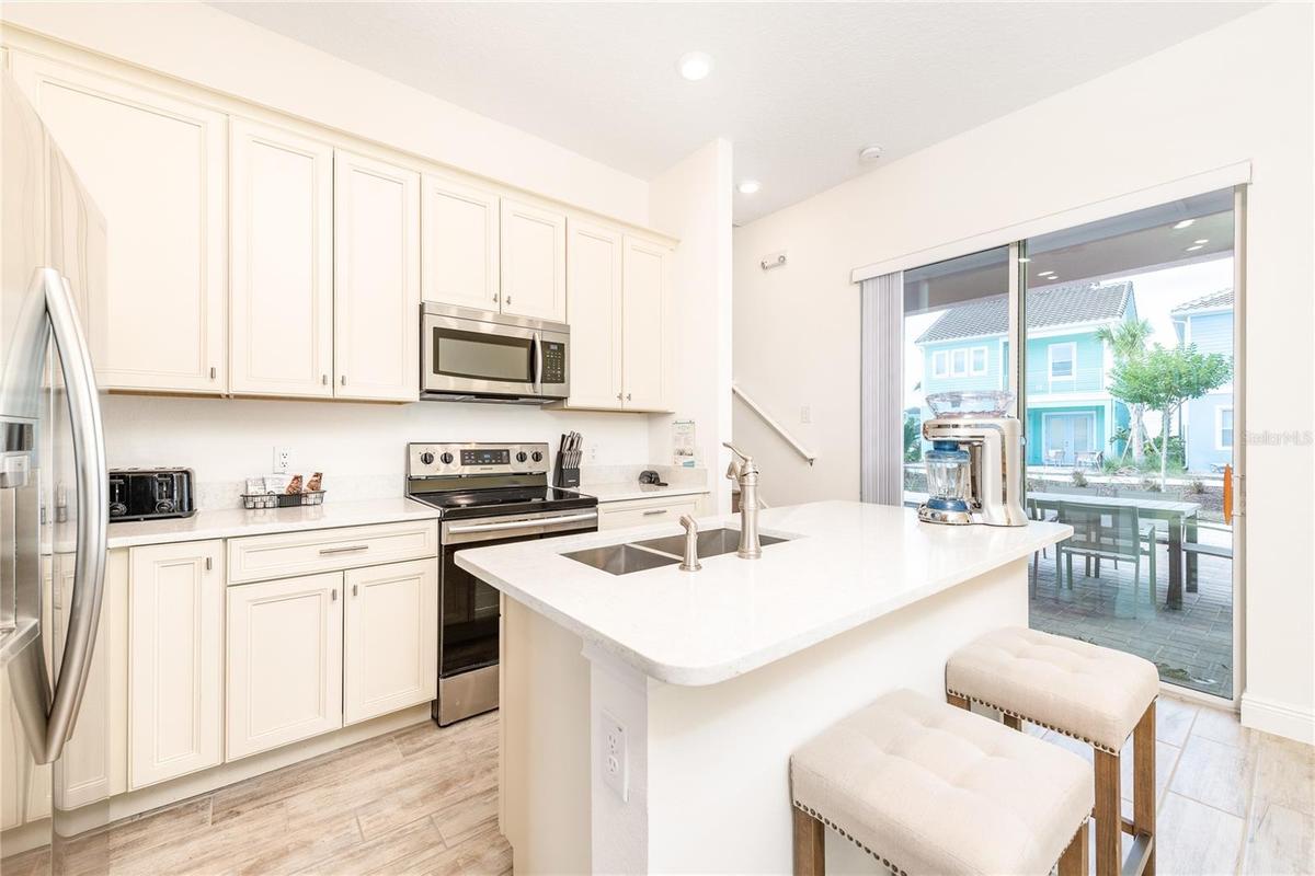 Open concept kitchen with quartz countertops and stainless steel appliances in Margaritaville Resort Orlando