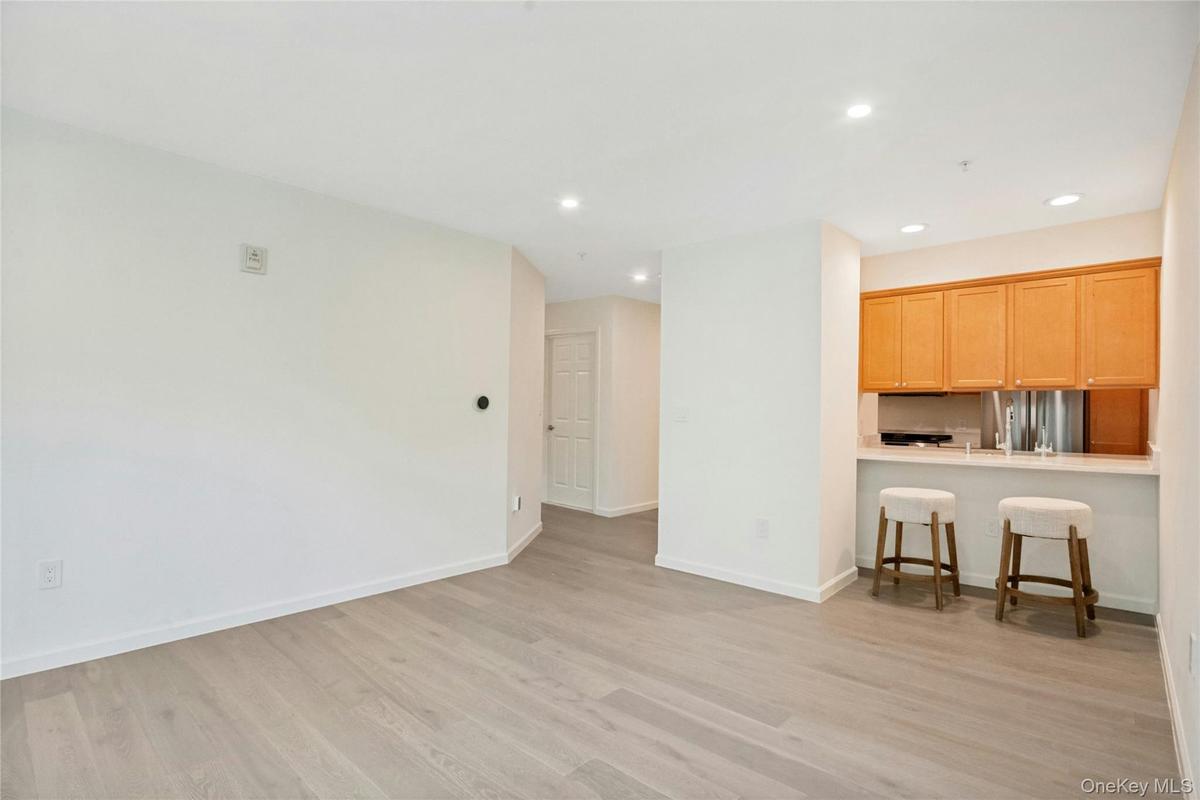 Open-concept living/ dining space featuring European white oak flooring and breakfast bar