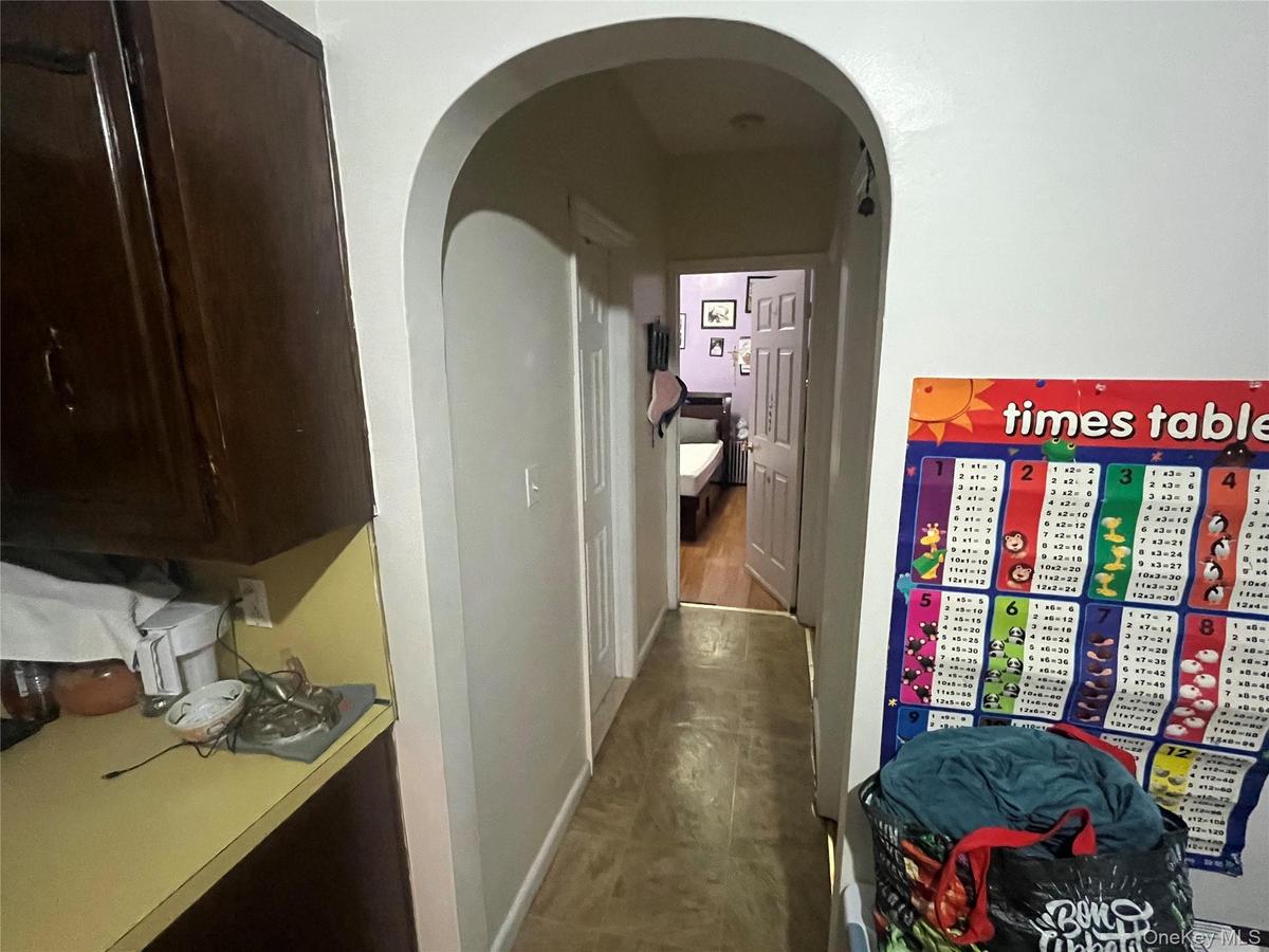 Hallway with arched walkways and baseboards
