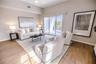 Open concept living and dining room with natural light and balcony overlooking mangroves.