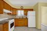 Kitchen in the 2 BR unit, featuring wood cabinets and white updated appliances