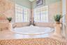 Primary Bathroom with dual granite vanities, Spacious Walk-In Shower with 7 heads and detachable hose and a large, separate tub