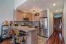 Kitchen featuring appliances with stainless steel finishes, a kitchen bar, a peninsula, dark wood-type flooring, and recessed lighting