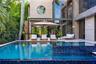 Oversized pool and elevated spa with blue mosaic tile waterfall spillover, teak chaise lounges, cantilever umbrella, woven lounge seating, large-forma