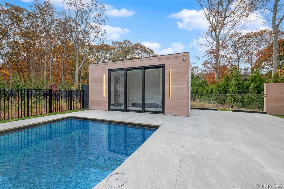 View of swimming pool featuring an outbuilding, a patio area, and a storage structure