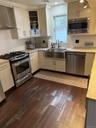 Kitchen with a sink, ventilation hood, dishwashing machine, range, and dark wood-style flooring