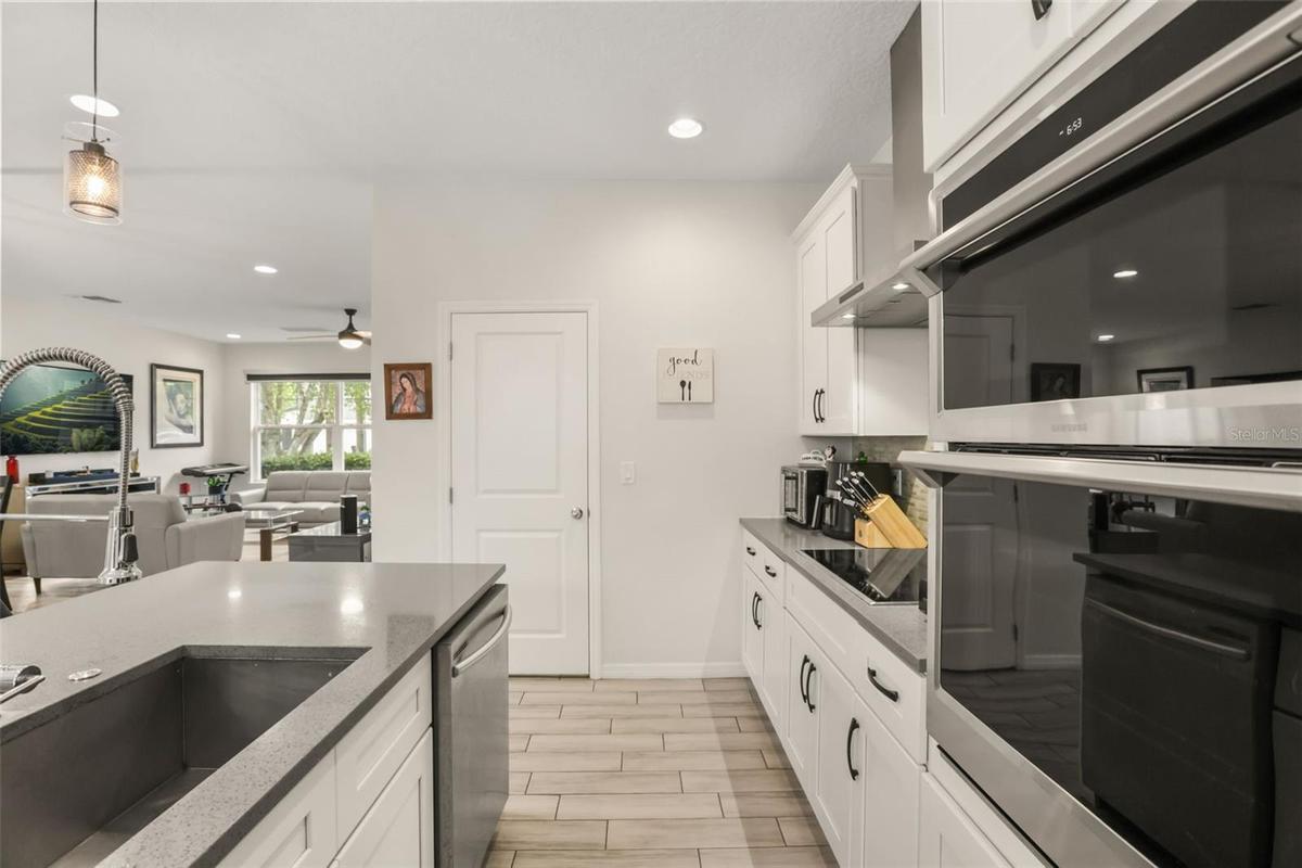 Well-appointed kitchen featuring built-in oven and microwave, solid surface countertops, abundant cabinetry, and a functional layout for everyday livi