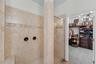 Walk-in shower with neutral tile and spacious design.