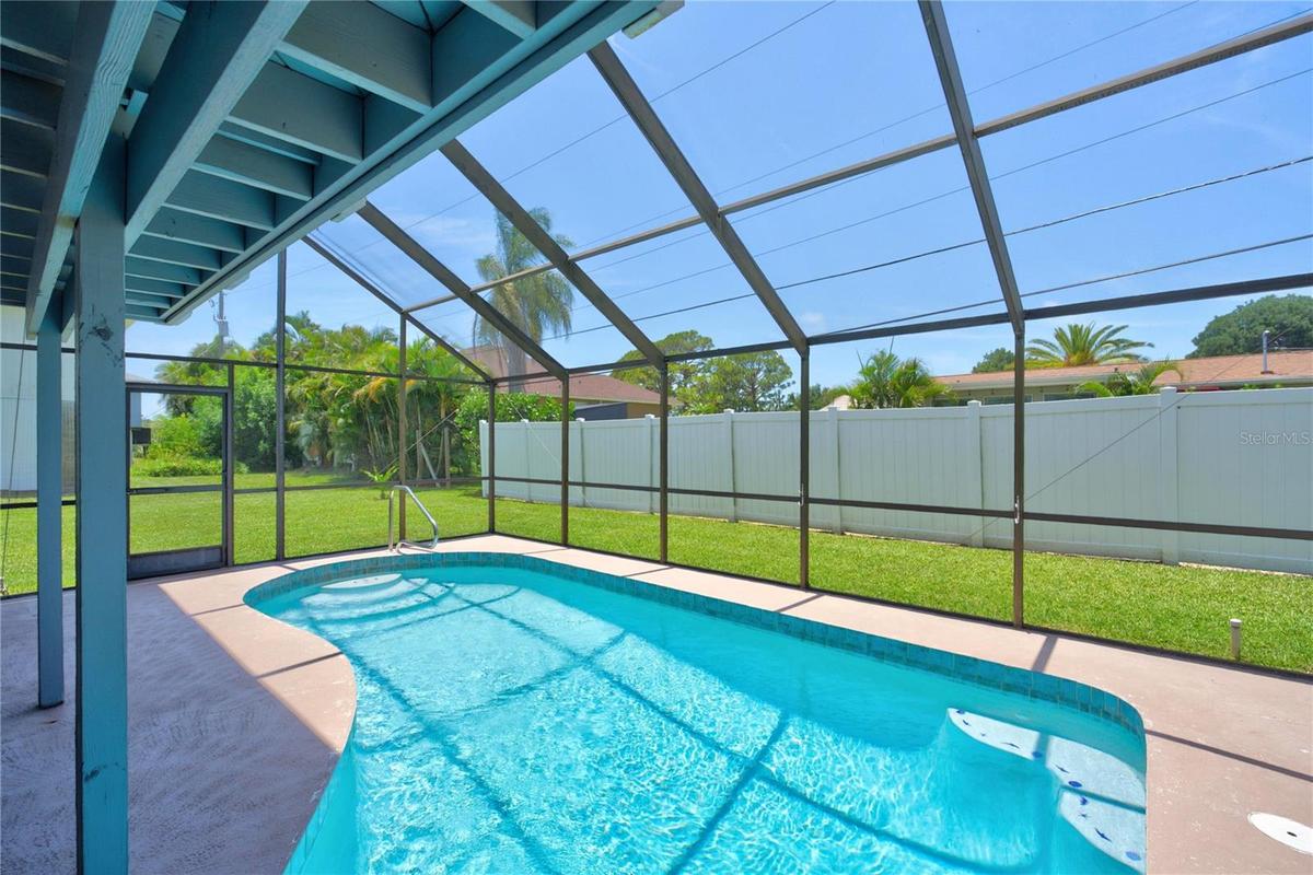 Screened-in swimming pool with expansive deck space