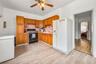 Kitchen with a ceiling fan, white fridge with ice dispenser, light countertops, light wood-style flooring, and black gas stove