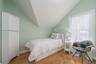 Bedroom featuring vaulted ceiling, wood finished floors, and baseboards