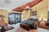 Warm & Inviting Primary Suite with Terracotta Tile, Wood Ceiling Detail, and Private Patio with Full Bay View