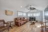 Living area featuring baseboard heating, wood finish floors, and ceiling fan