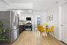 Kitchen with modern cabinets, light wood-style floors, white cabinetry, light countertops, and appliances with stainless steel finishes
