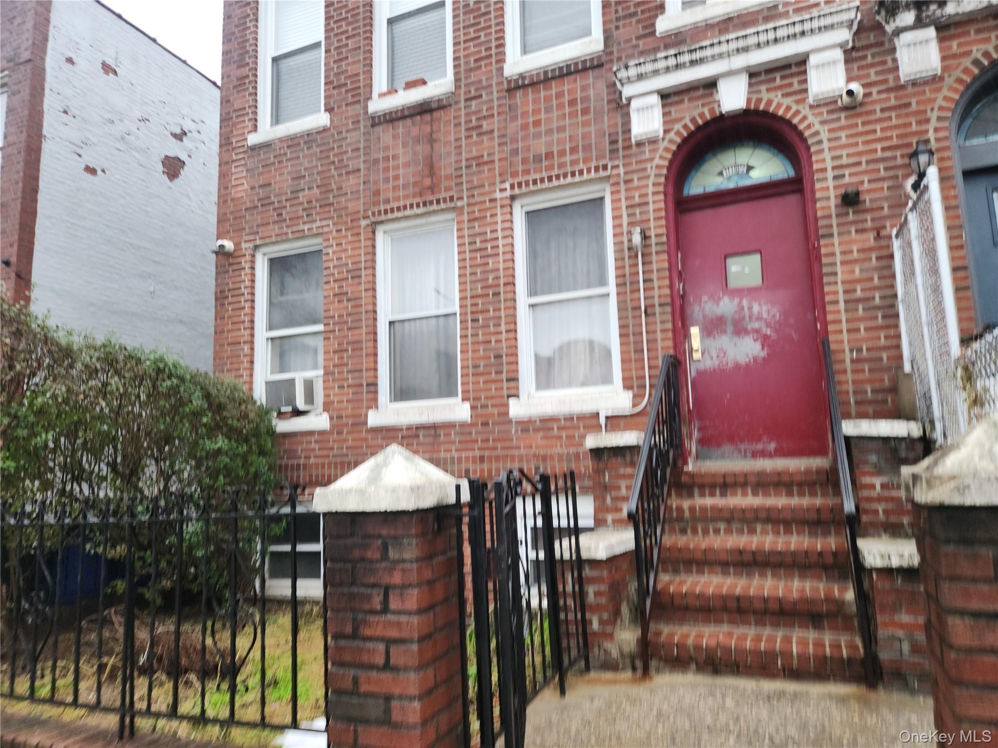 View of exterior entry featuring brick siding and a gate
