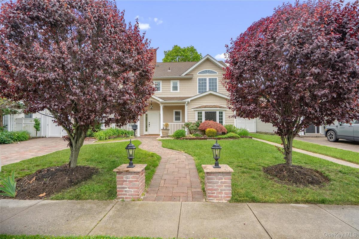 Two-story residence featuring expansive paver stone entry walkway
