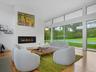 Living room with a glass covered fireplace, light wood finished floors, and recessed lighting