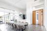 Dining area with concrete flooring, a towering ceiling, and track lighting